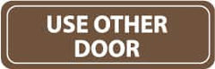 NMC - Use Other Door, 11" Wide x 3.5" High, Acrylic Sign - English, White on Brown, Wall Mount - Americas Industrial Supply